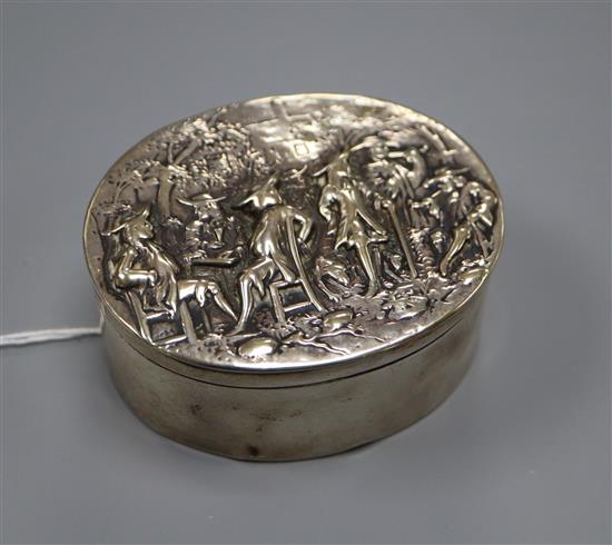 A George III silver oval box with cover embossed with gentleman socialising,